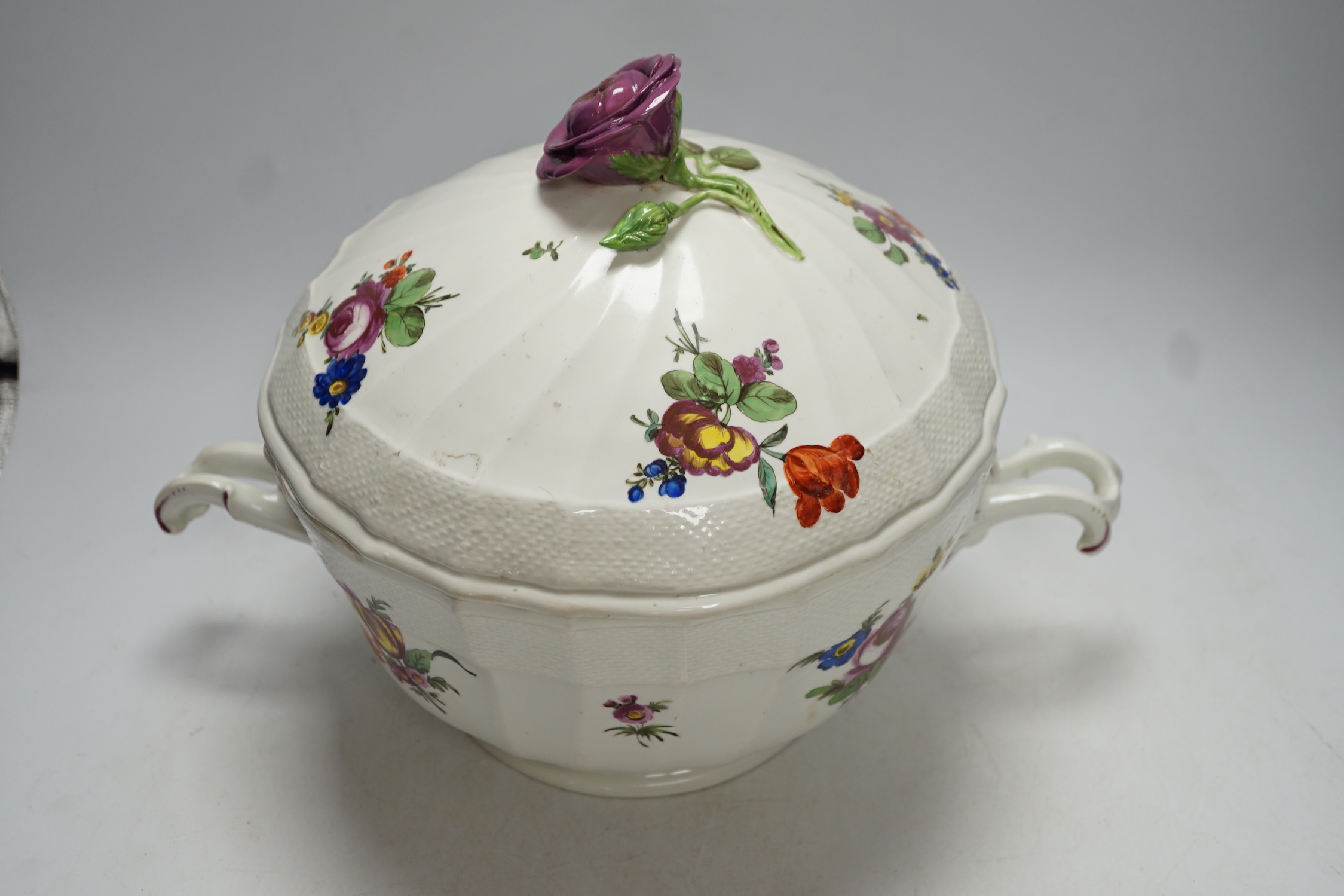 An 18th century Vienna tureen and cover, later outside decorated, with twin handles and floral knop, 38cm wide